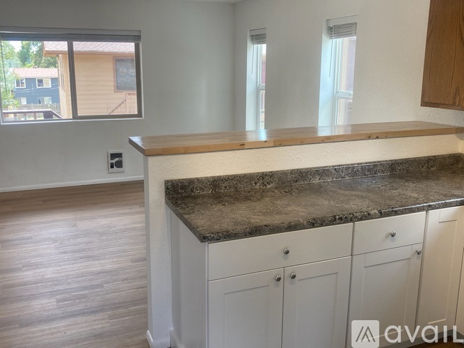 A kitchen with a granite countertop and wooden cabinets.