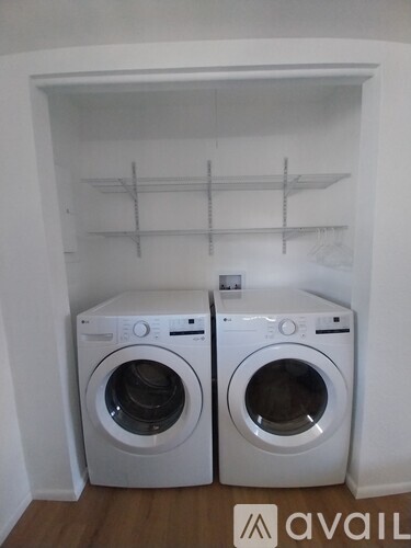 Two white front loading washing machines in a laundry room.