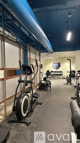A gym with exercise equipment and a logo on the wall.
