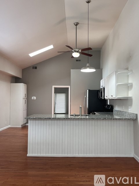 A kitchen with a counter and a fan.