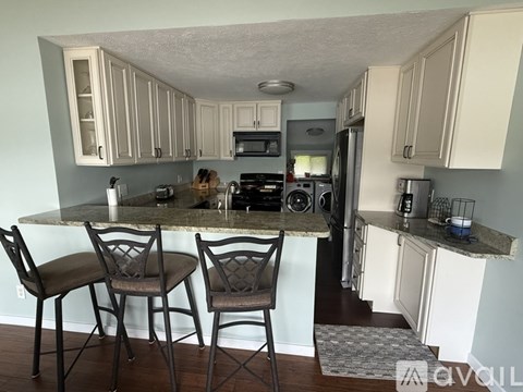 A kitchen with a marble countertop and white cabinets.