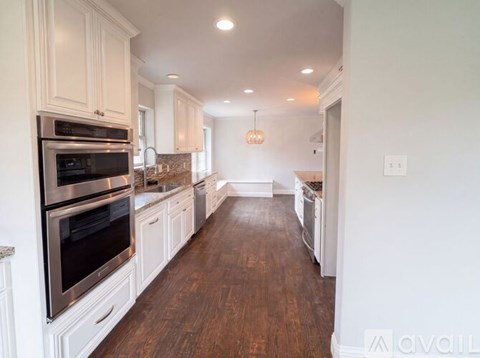 A kitchen with white cabinets and stainless steel appliances.