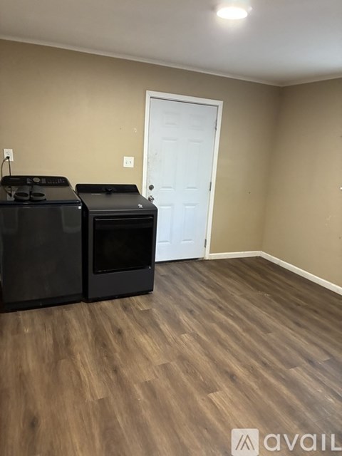 A kitchen area with two black ovens and a white door.