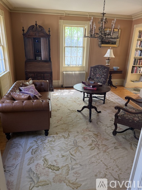 A living room with a brown leather chair and a wooden cabinet.