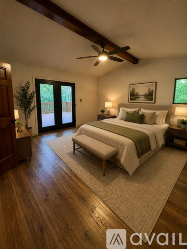 A bedroom with a large bed and a ceiling fan.