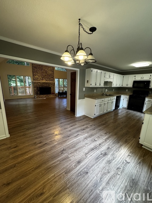 A kitchen with wooden floors and white cabinets.