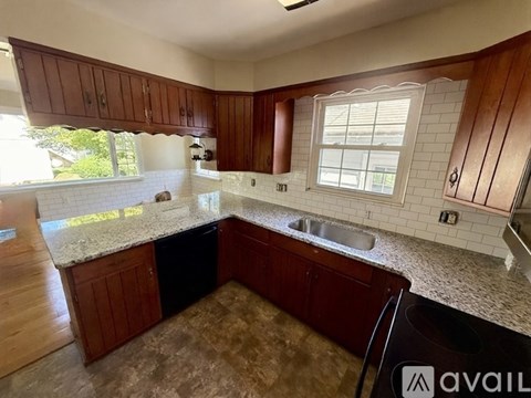 A kitchen with brown cabinets and a granite countertop.