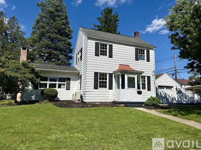 A two-story house with a grey exterior and a red roof.