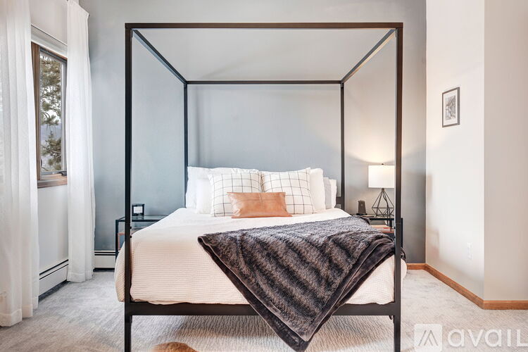 A bedroom with a four poster bed and a white bedspread.