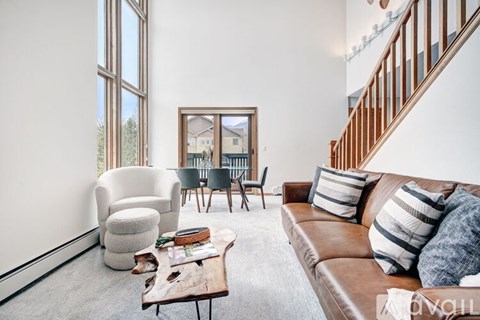 A living room with a brown leather couch and a wooden coffee table.
