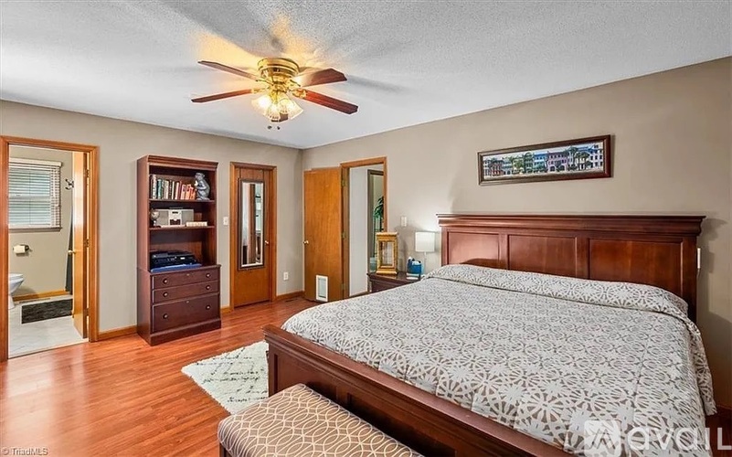 A bedroom with a large bed and a ceiling fan.