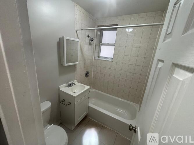 A white bathroom with a toilet, sink, and bathtub.
