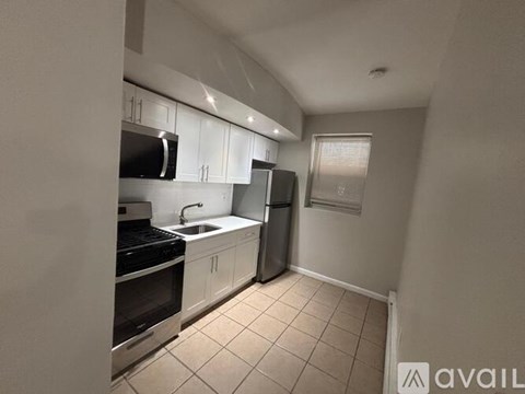 A kitchen with white cabinets and appliances.