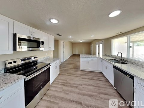 A kitchen with white cabinets and a black stove top oven.
