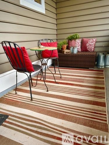 A striped rug covers the floor of a small patio.