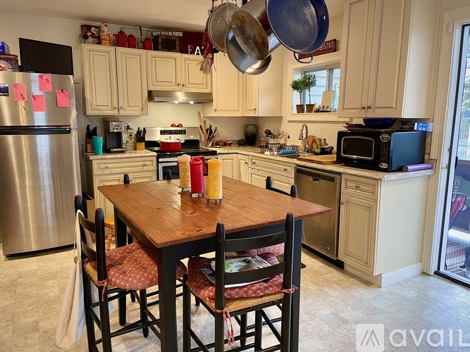 A kitchen with a table and chairs in the foreground and a refrigerator in the background.