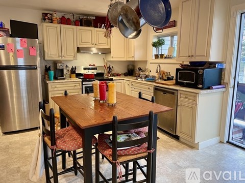 A kitchen with a table and chairs in the foreground and a refrigerator in the background.
