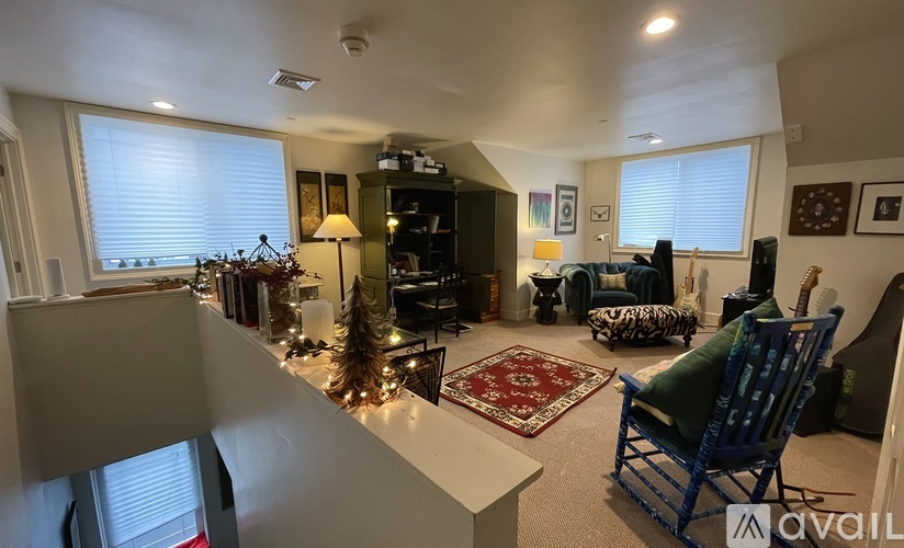 A living room with a blue chair and a rug.