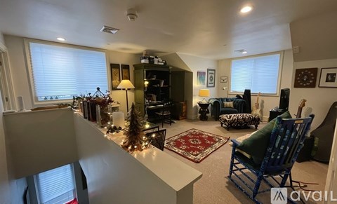 A living room with a blue chair and a rug.