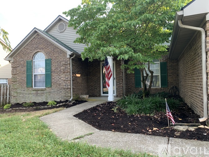 A house with a flag on the front lawn.