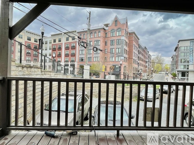 A view from a balcony overlooking a parking lot and buildings.