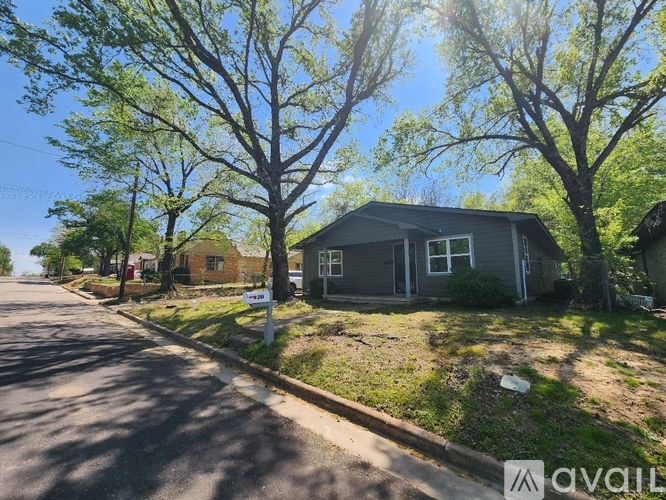 A house is for sale in a sunny suburban area.