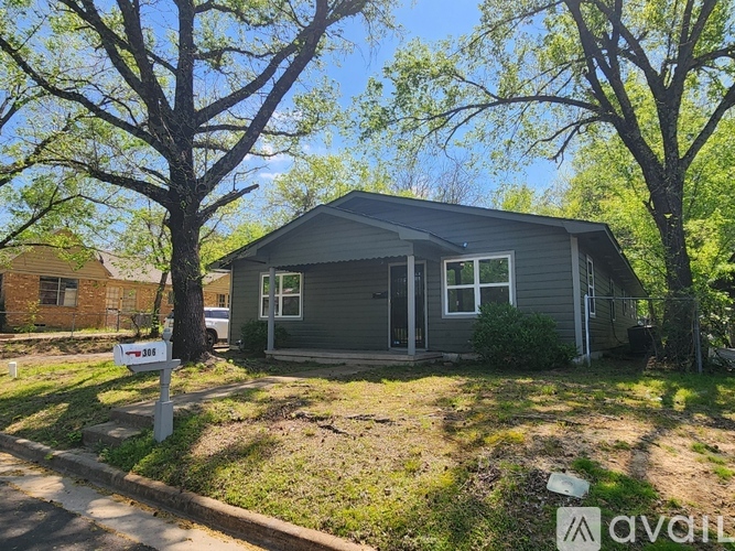 A house with a sign that says "For Sale" in front of it.