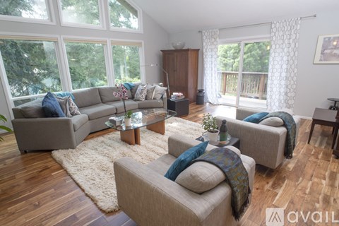 A living room with a grey couch and a wooden floor.