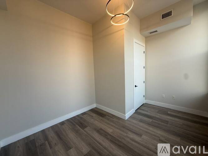 A room with a white door and a wooden floor.
