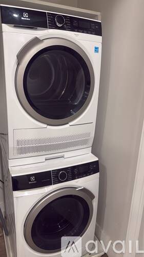 A stack of two white front loading washing machines.