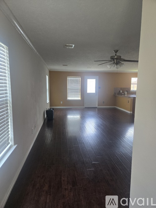 A room with a ceiling fan and wooden flooring.