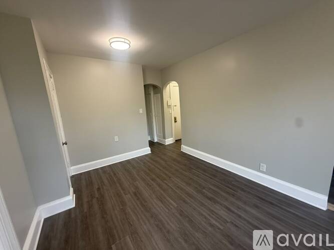 A room with wooden flooring and a white door.