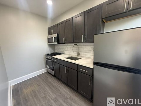 A kitchen with dark wood cabinets and a stainless steel refrigerator.