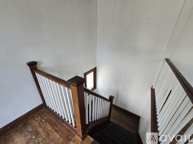 A wooden staircase with a white railing.