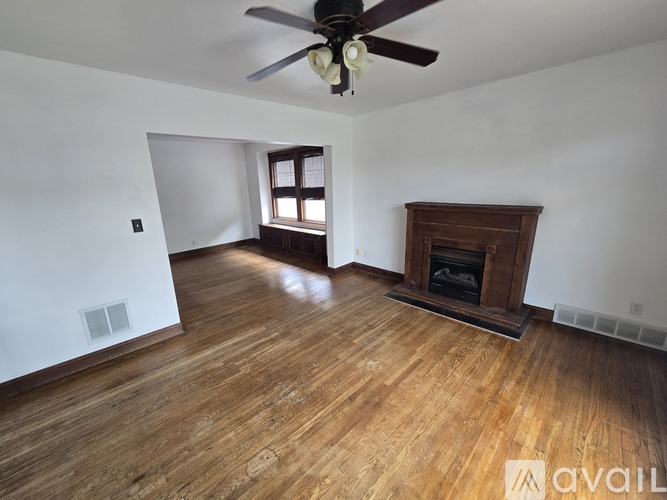 A room with a fireplace and a ceiling fan.