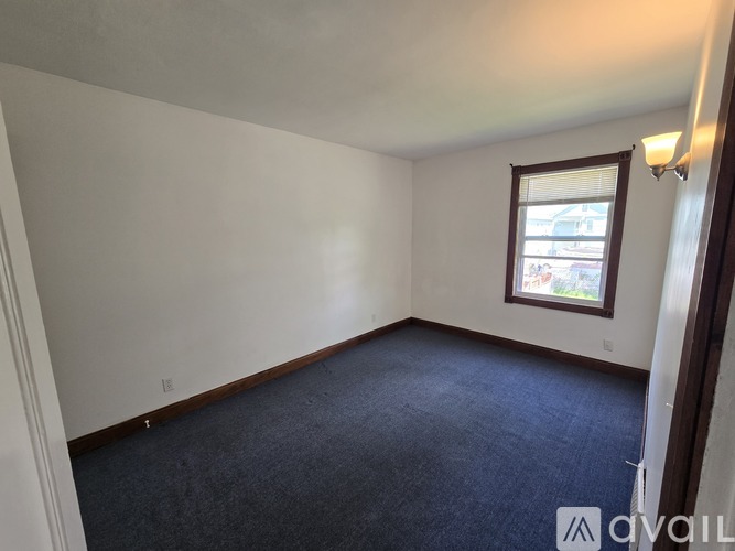 A room with a carpeted floor and a window.