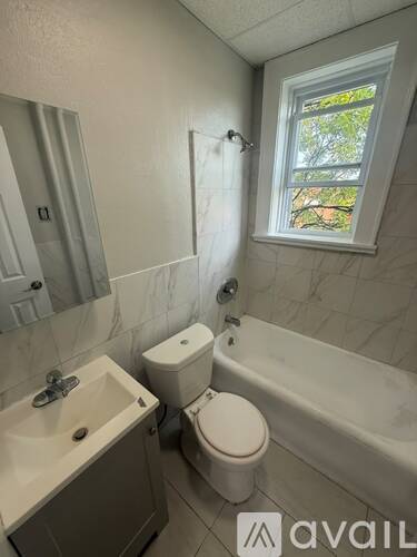A bathroom with a toilet, sink, and bathtub.