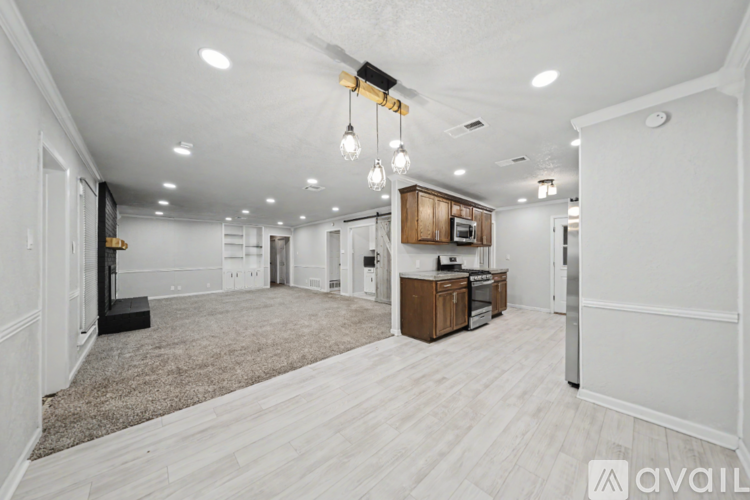 A spacious, well-lit kitchen area with a refrigerator, microwave, and oven.