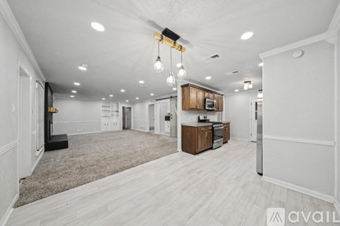 A spacious, well-lit kitchen area with a refrigerator, microwave, and oven.