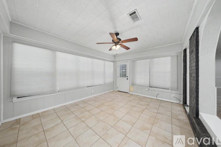 A spacious room with a ceiling fan and tiled flooring.