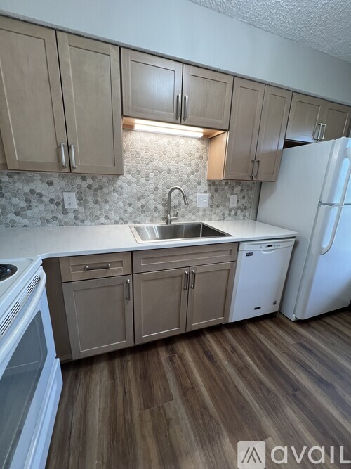 A kitchen with wooden cabinets and a white refrigerator.