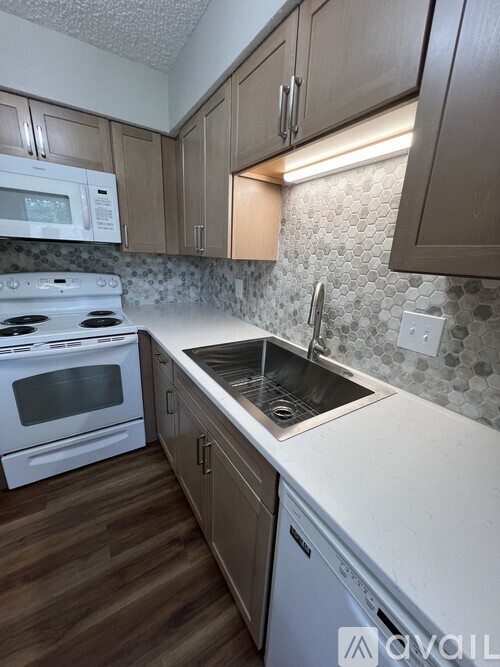 A kitchen with a white stove top oven and a white microwave.