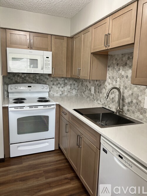 A kitchen with wooden cabinets and a white oven.