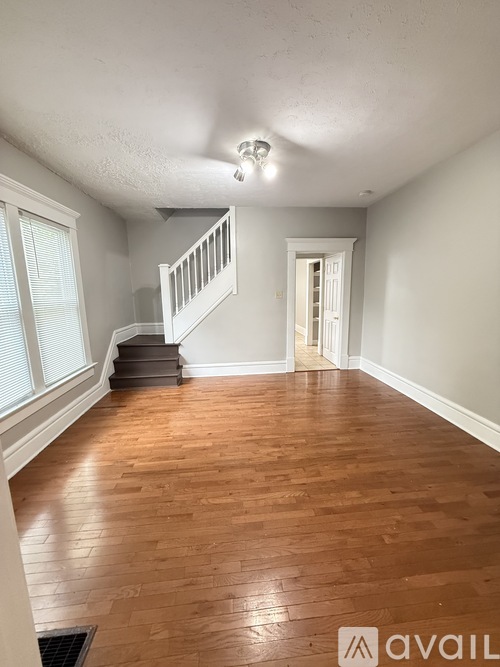 A room with wooden floors and a staircase.