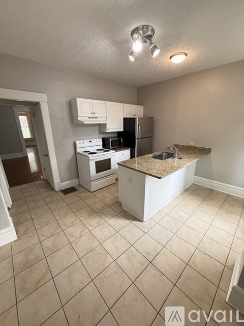 A kitchen with a white stove and a white refrigerator.