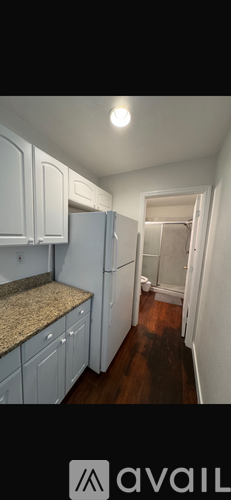 A kitchen with white cabinets and a granite countertop.