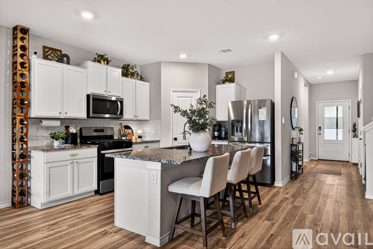 A kitchen with white cabinets and a wooden floor.