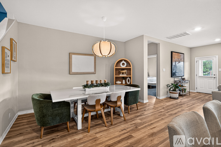 A dining room with a white table and green chairs.