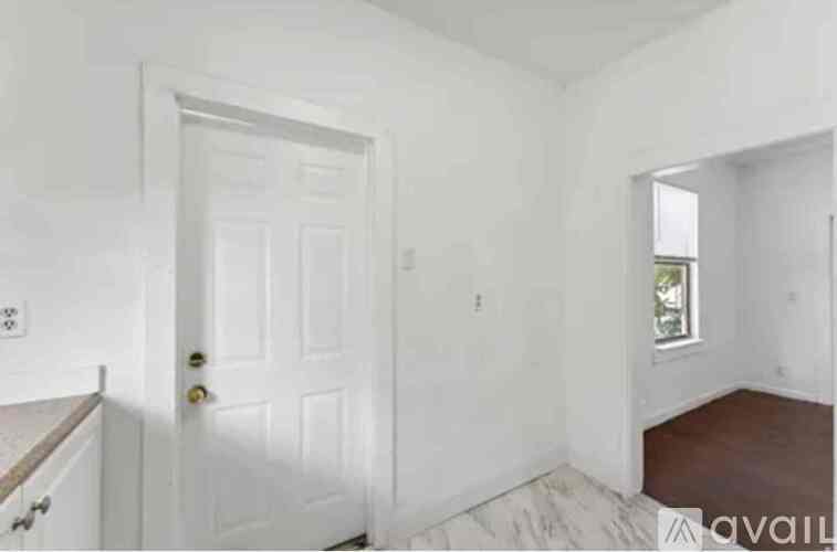 A white door is in a room with white walls.