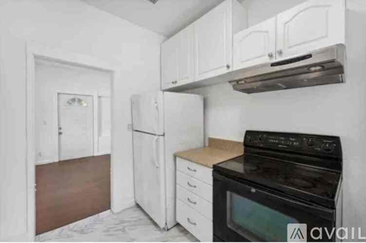 A kitchen with white cabinets and a black stove top oven.